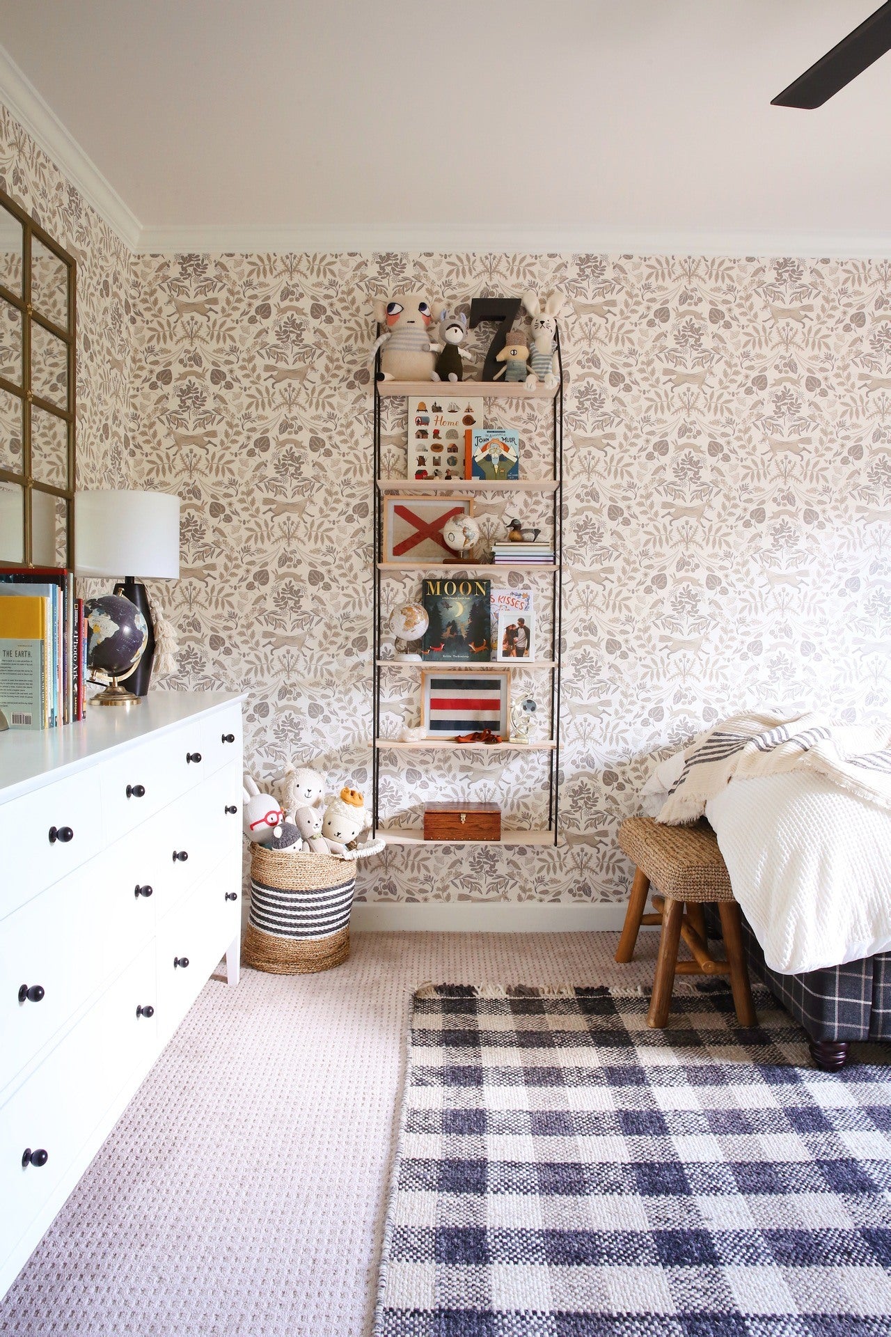 Another angle of the bedroom shows a shelf filled with childrens books, antiques, and other accessories. 