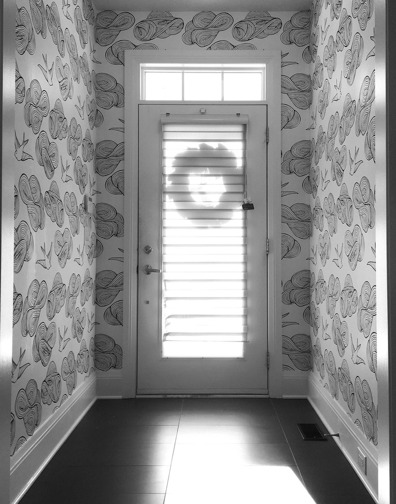 A brightly lit entryway featuring Daydream (Black) wallpaper installed by Roll Her Sleeves