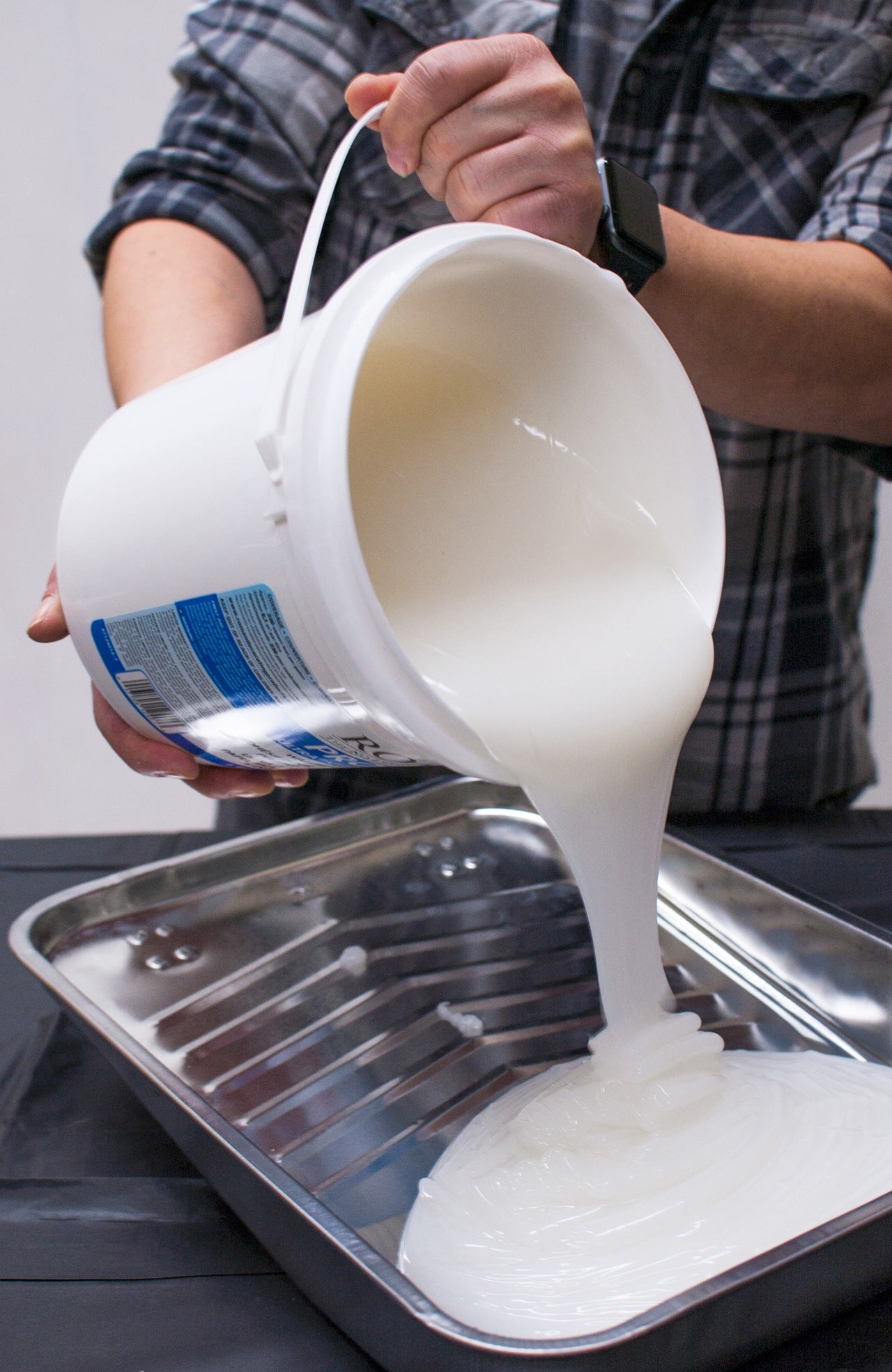 Roman wallpaper paste being poured into a paint tray